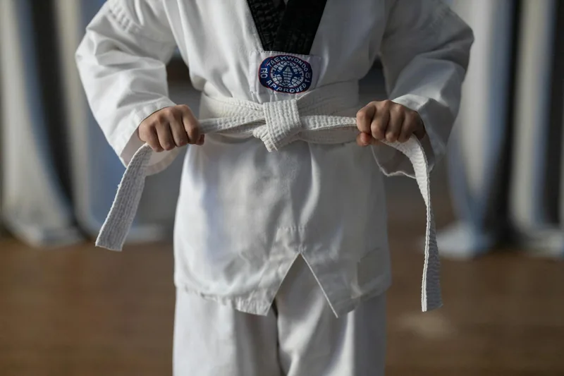 Young student earning a martial arts belt rank at GMA Academy